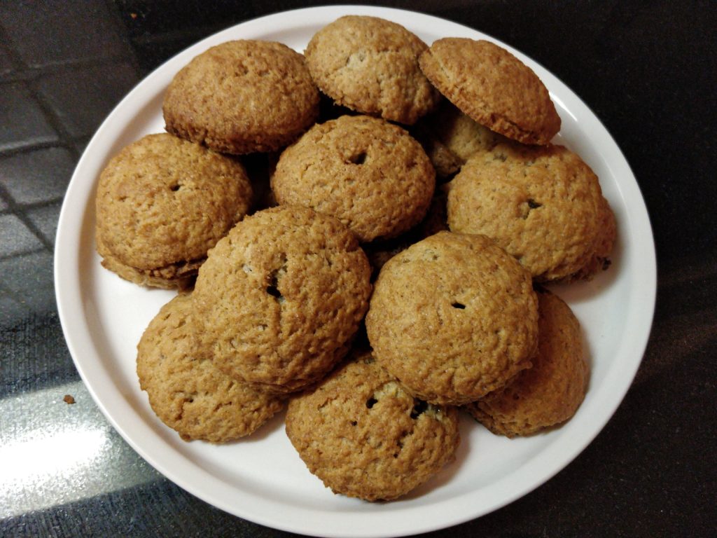 Angel's hair cookies on a white dish, resting on a black counter.